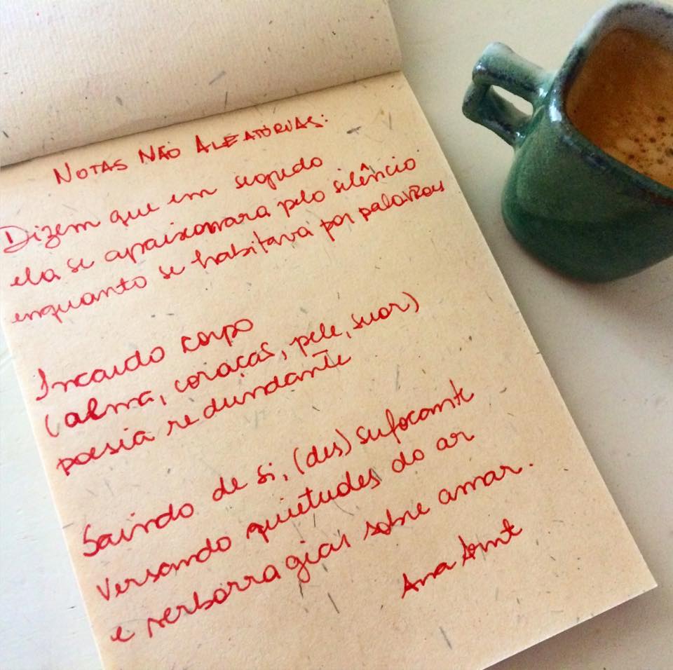 foto com a poesia escrita à mão em um bloco de papel, junto com um café