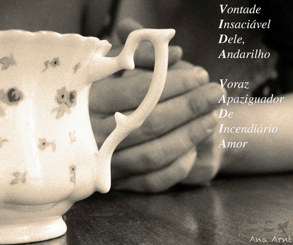 Fotografia em preto e branco. No primeiro plano uma xícara, atrás, duas mãos fechadas, fora de foco.
A poesia está escrita na foto.