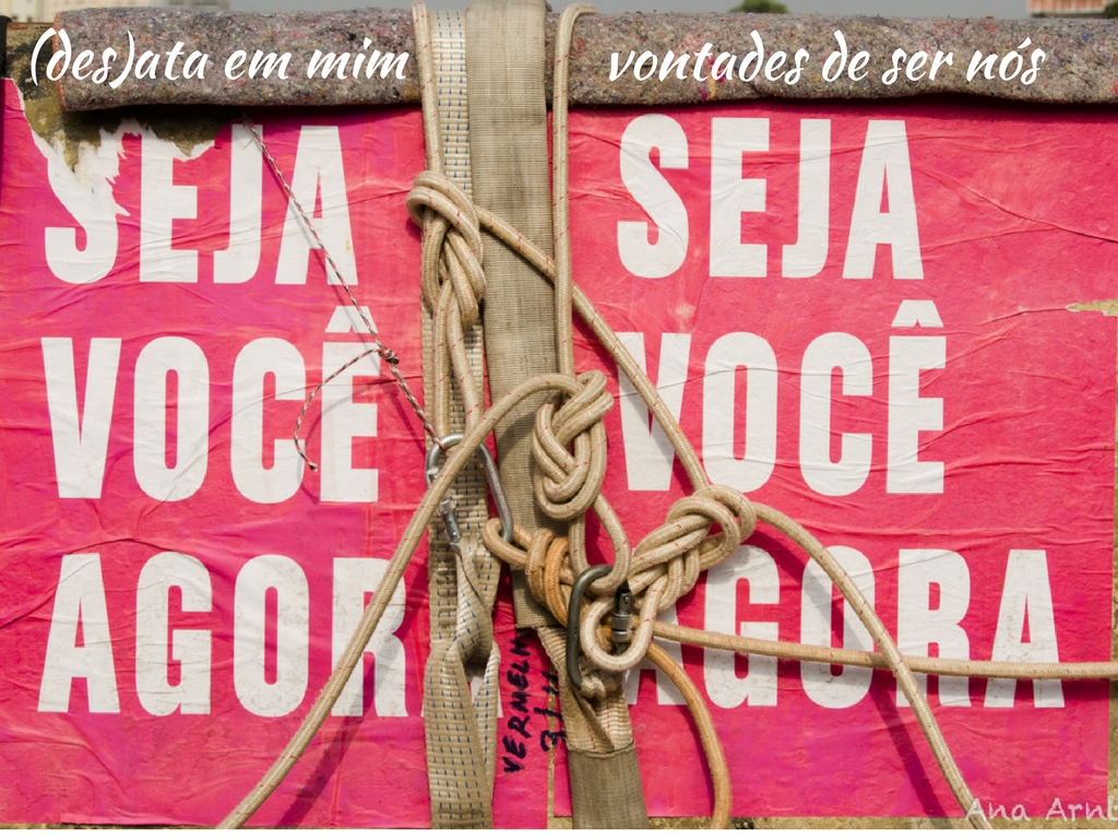 Foto de lambes em um muro escrito "seja você agora". Neste muro há cordas, com nós. E escrito digitalmente por cima "desata em mim vontade de ser nós"